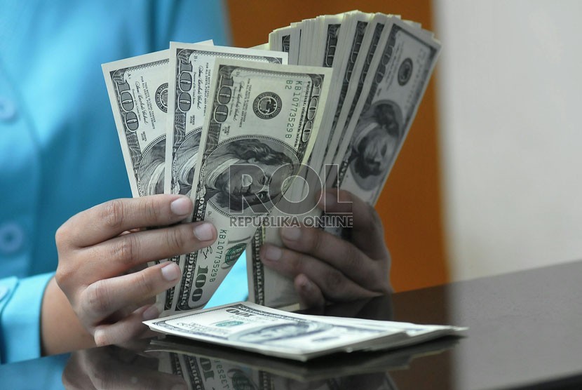 Petugas menghitung mata uang Dolar AS di jasa penukaran mata uang, Jakarta,Senin (11/8). (Republika/Prayogi)
