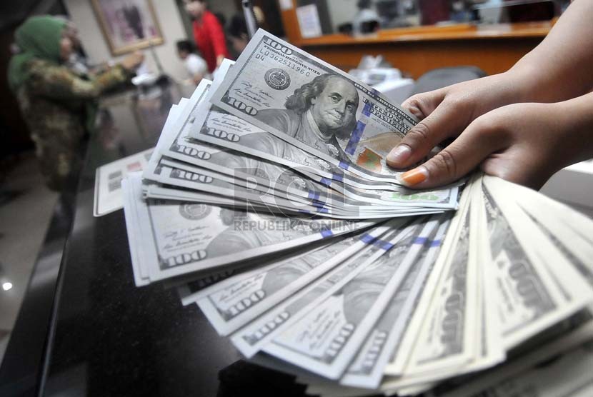Petugas menghitung mata uang Dolar AS di jasa penukaran mata uang, Jakarta,Kamis (18/9). (Prayogi/Republika)
