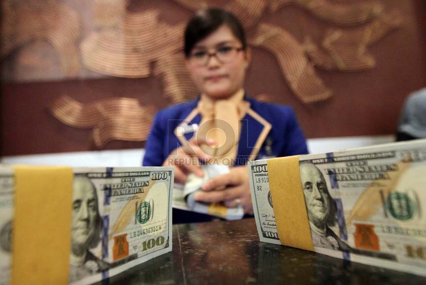 Petugas menghitung mata uang dollar Amerika, di Kantor Bank BRI, Jakarta, Kamis (3/7).(Republika/Adhi Wicaksono).