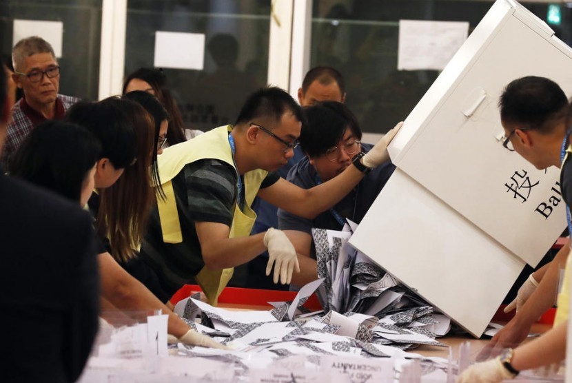 Petugas menghitung surat suara dalam Pemilu di Hong Kong pada Ahad (24/11). 
