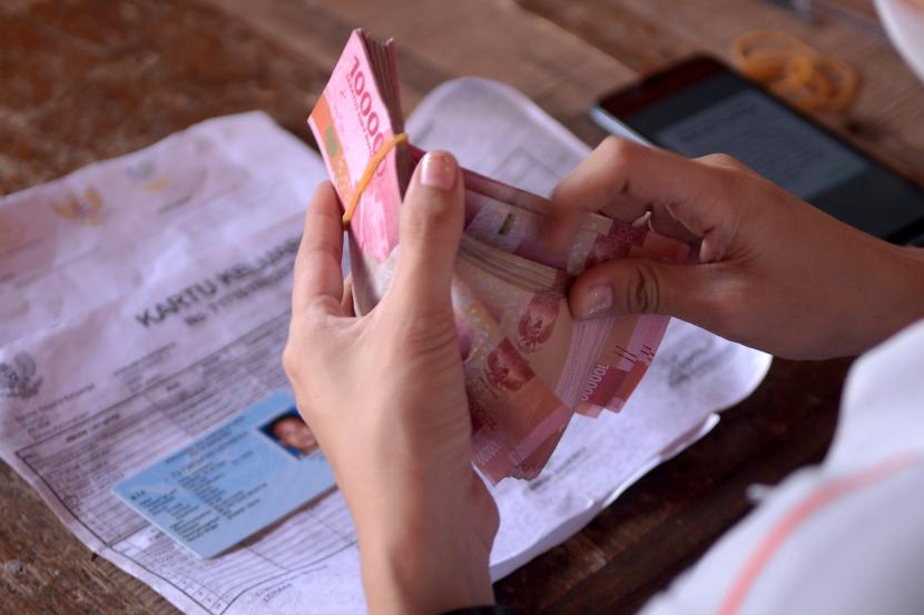 Petugas menghitung uang Bantuan Langsung Tunai (BLT) Bahan Bakar Minyak (BBM) (ilustrasi).