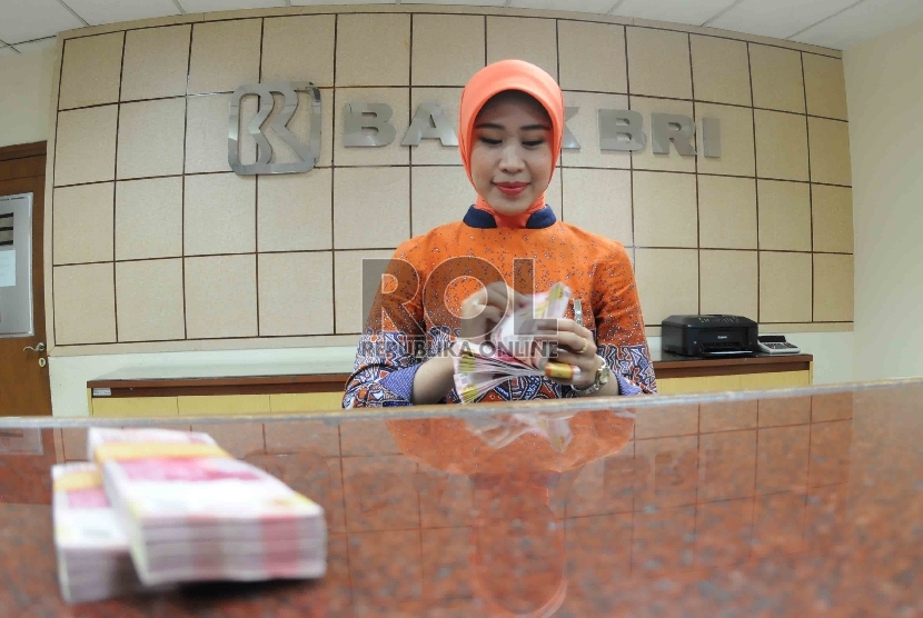 Petugas menghitung uang di banking hall Bank Rakyat Indonesia, Jakarta, Selasa (20/10).