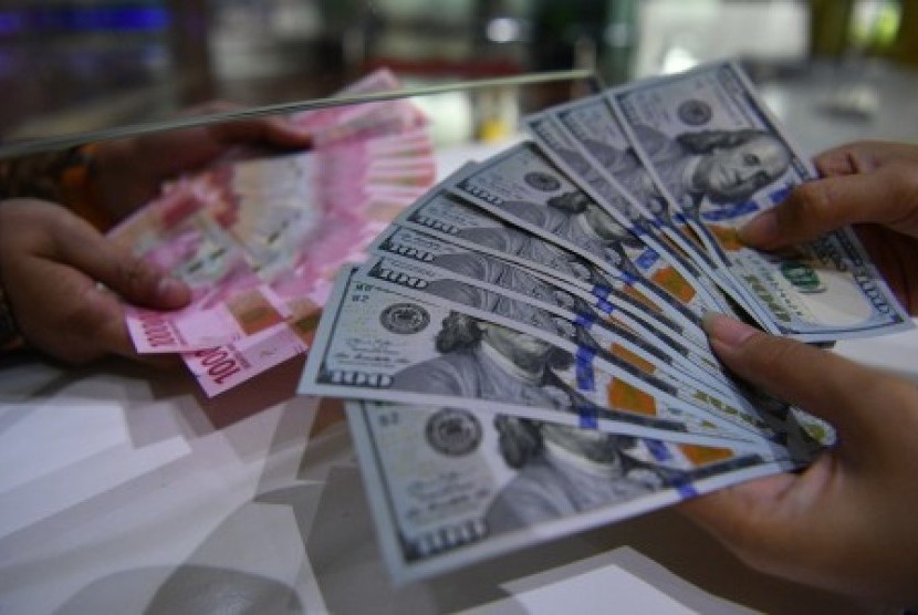 Petugas menghitung uang dolar Amerika Serikat di gerai penukaran mata uang Bank BTN, Jakarta, Jumat (20/7). 