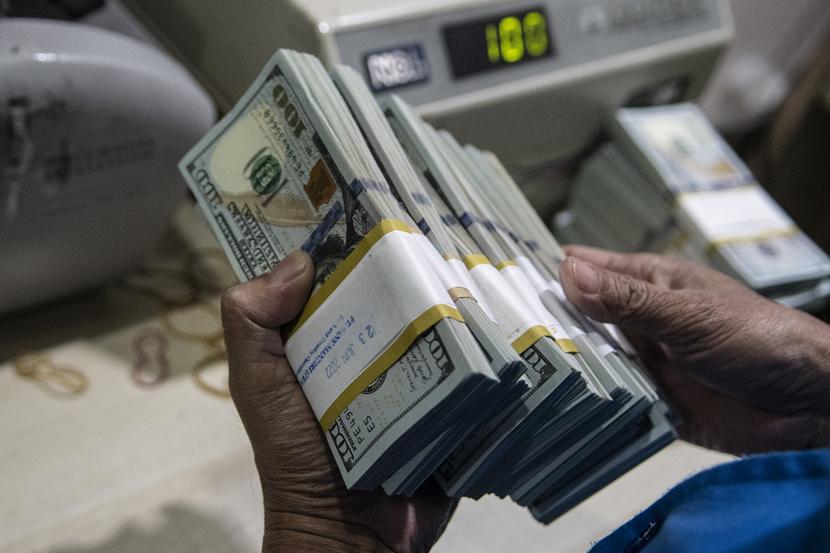 Petugas menghitung uang dolar AS di sebuah bank di Jakarta, Kamis (23/6/2022).