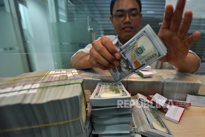 Petugas menghitung uang dolar AS (ilustrasi). Bank Indonesia (BI) mencatat posisi cadangan devisa Indonesia pada akhir November 2020 mencapai 133,6 miliar dolar AS.
