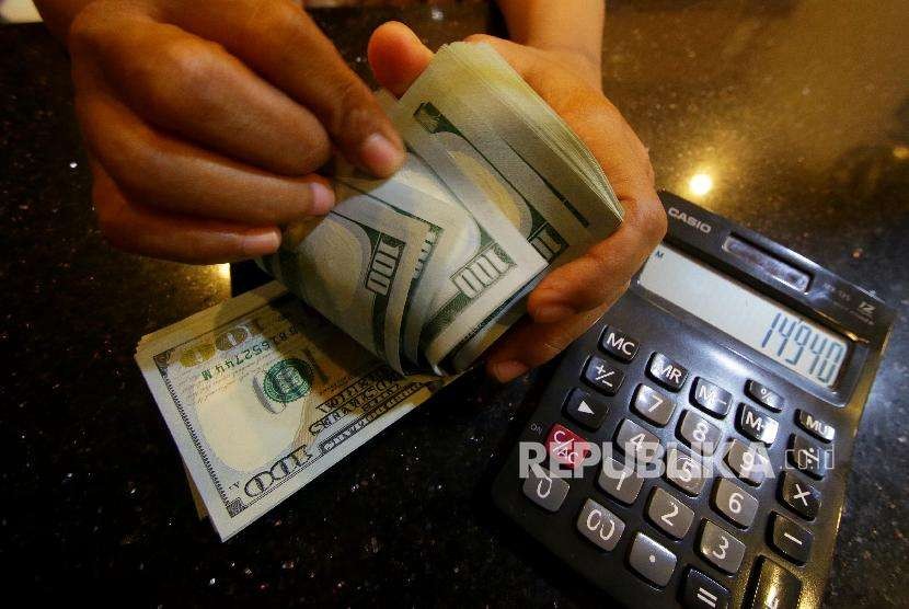 Petugas menghitung uang pecahan dolar Amerika Serikat di gerai penukaran mata uang asing di Jakarta (ilustrasi)