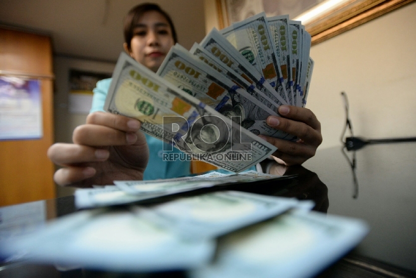 Petugas menghitung uang pecahan Dolar AS di salah satu tempat penukaran uang, Jakarta, Senin (2/2).(Republika/Prayogi)