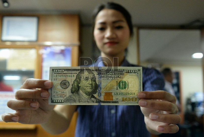Petugas menghitung uang pecahan Dolar AS di salah satu tempat penukaran uang, Jakarta, Kamis (23/4).  (Republika/Prayogi)