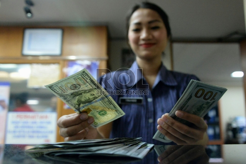 Petugas menghitung uang pecahan Dolar AS di salah satu tempat penukaran uang, Jakarta, Kamis (23/4).  (Republika/Prayogi)