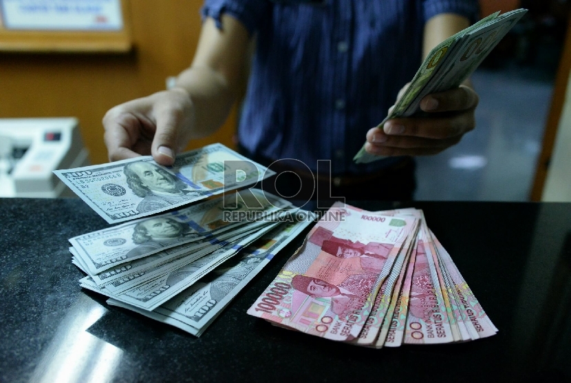 Petugas money changer menghitung uang pecahan Dolar AS. (Republika/Prayogi)
