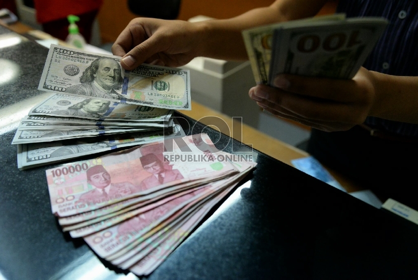 Petugas menghitung uang pecahan Dolar AS di salah satu tempat penukaran uang, Jakarta, Kamis (23/4).  (Republika/Prayogi)
