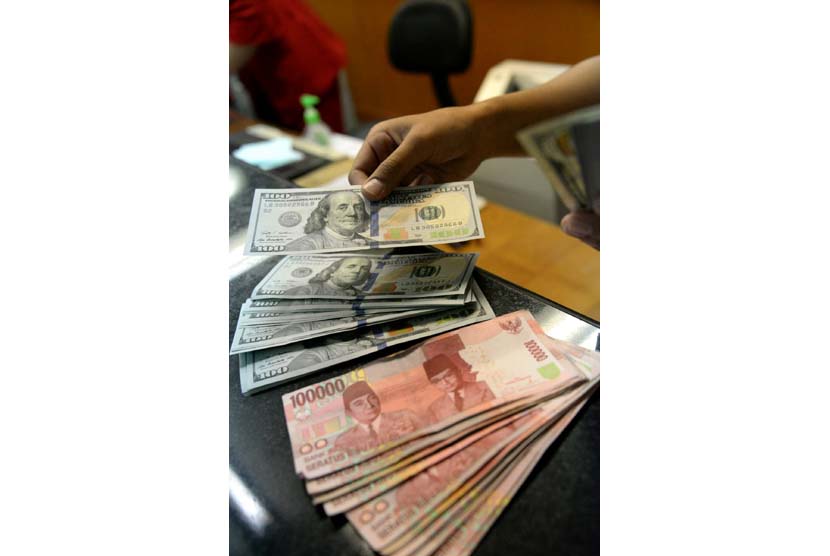 Petugas menghitung uang pecahan Dolar AS di salah satu tempat penukaran uang, Jakarta, Kamis (23/4).  (Republika/Prayogi)