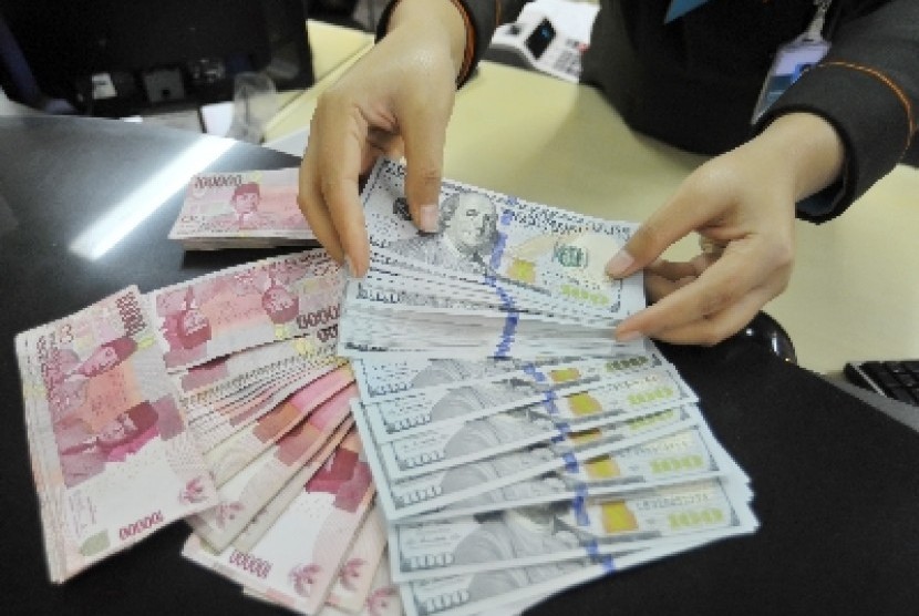   Petugas menghitung uang pecahan rupiah di layanan nasabah Bank BNI, Jakarta, Jumat (13/3).