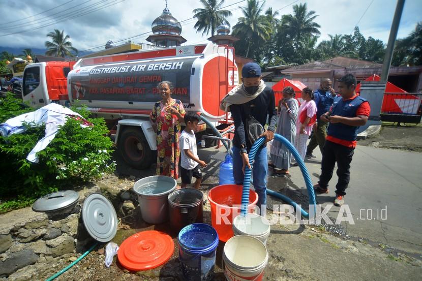 Petugas mengisi air bersih untuk warga korban gempa di Nagari Kajai, Kabupaten Pasaman Barat, Sumatera Barat, Selasa (8/3/2022). Palang Merah Indonesia (PMI) menyalurkan sedikitnya 1.000 liter air bersih per hari untuk kebutuhan mandi cuci kakus (MCK) dan minum korban gempa di Kabupaten Pasaman Barat dan Pasaman. 