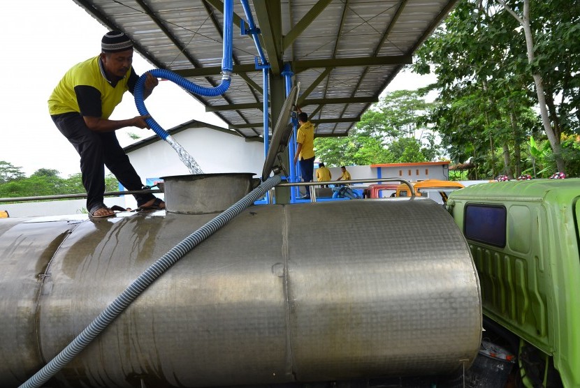 Petugas mengisi air ke dalam truk tangki air minum di tempat pengisian air di Cendono, Kudus, Jawa Tengah, Rabu (23/3).