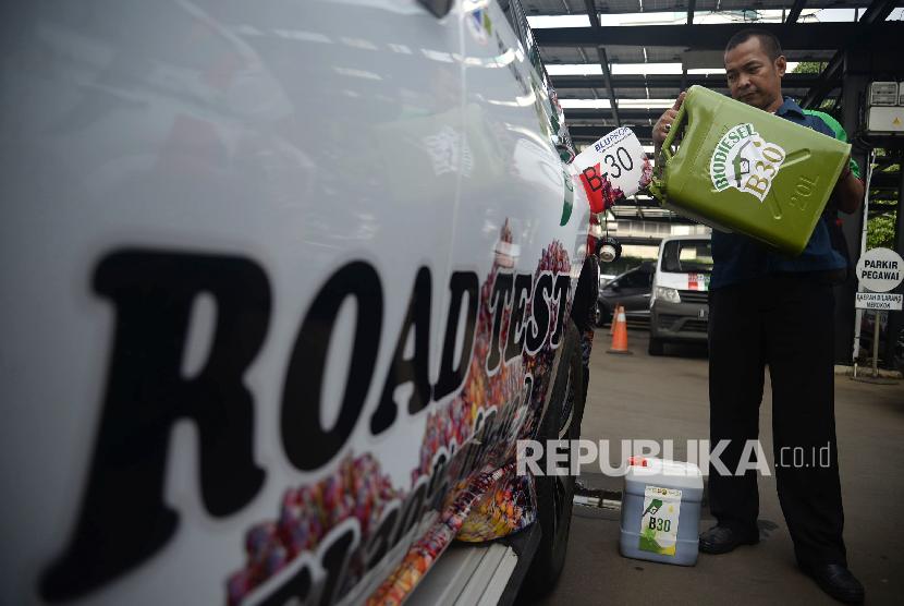 Petugas mengisi bahan bakar B30 ke kendaraan saat peluncuran uji jalan Penggunaan Bahan Bakar B30 untuk kendaraan bermesin diesel di Kementerian ESDM, Jakarta, Kamis (13/6). Uji jalan kendaraan berbahan bakar campuran biodiesel 30 persen pada bahan bakar solar atau B30 dengan menempuh jarak 40 ribu dan 50 ribu kilometer tersebut bertujuan untuk mempromosikan kepada masyarakat bahwa penggunaan bahan bakar itu tidak akan meyebabkan performa dan akselerasi kendaraan turun.Prayogi/Republika