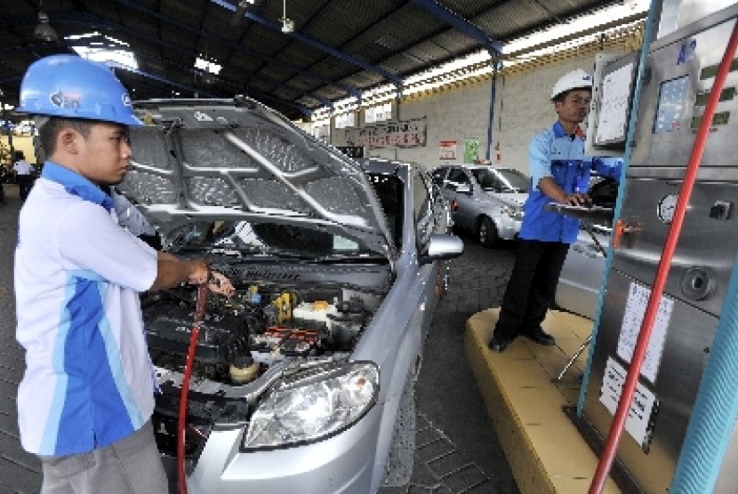 Petugas mengisi bahan bakar gas (BBG) ke sebuah mobil yang digunakan sebagai transportasi umum di Stasiun Pengisian BBG (SPBG) di Surabaya, Jawa Timur. 