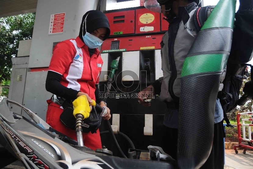 Petugas mengisi bahan bakar jenis premium di salah satu Stasiun Pengisian Bahan Bakar Umum (SPBU) di Jakarta, Rabu (30/12). 