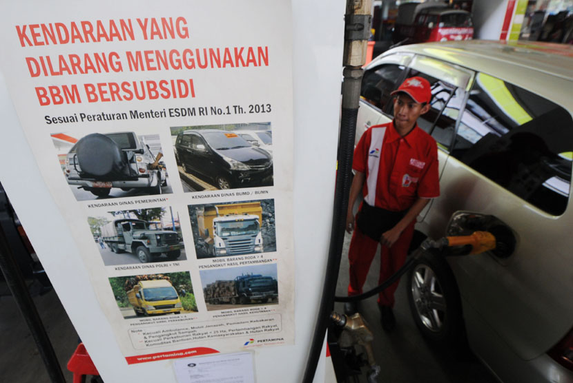 Petugas mengisi bahan bakar minyak (BBM) subsidi ke mobil konsumen di salah sati stasiun pengisian bahan bakar minyak umum (SPBU), Jakarta, Ahad (16/6). Sementara Menteri Keuangan Chatib Basri memastikan harga bahan bakar minyak (BBM) bersubsidi akan naik 