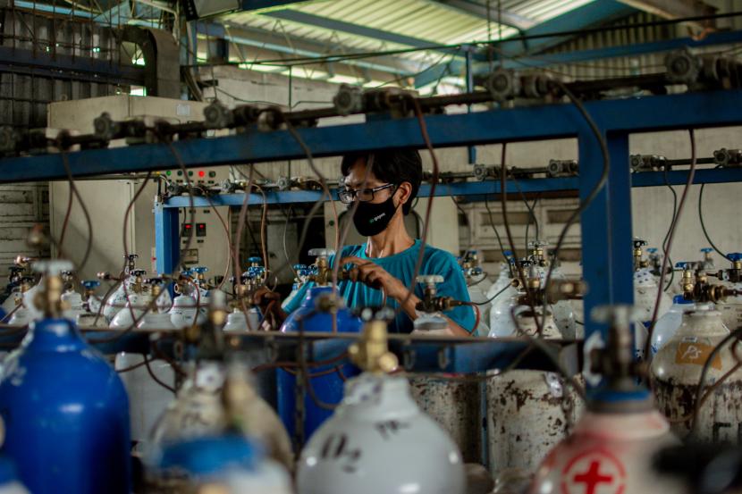 Petugas mengisi tabung oksigen di tempat pengisian oksigen Aneka Gas Industri di kawasan Cakung, Jakarta Timur.