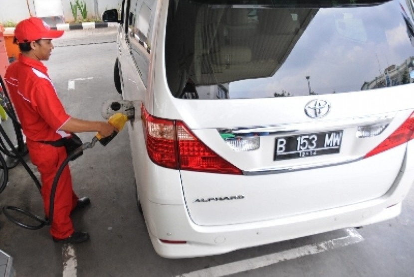 Petugas mengisikan bahan bakar minyak (BBM) bersubsidi atau premium pada mobil mewah di sebuah stasiun pengisian BBM umum (SPBU) di Cikini, Jakarta Pusat, Senin (2/4). 