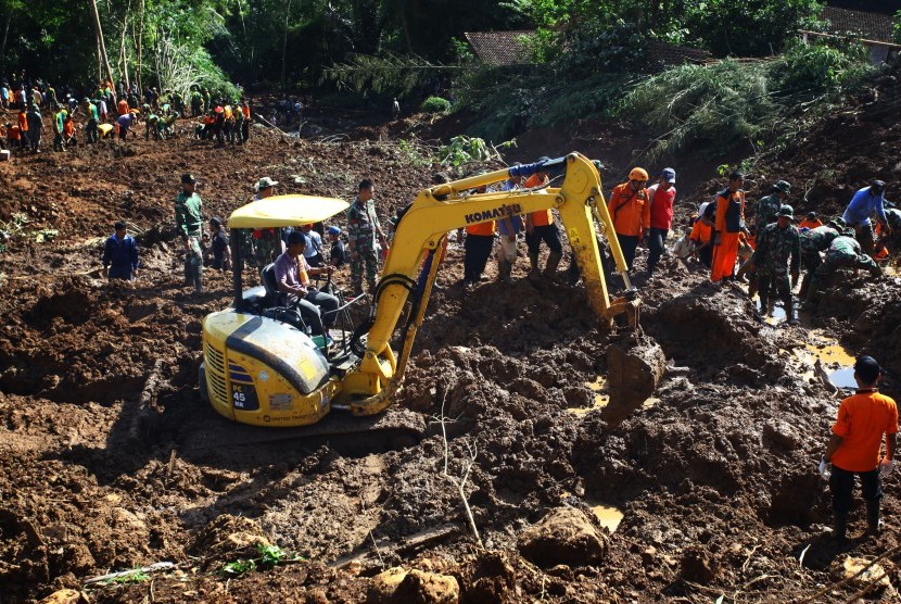 Petugas mengoperasikan alat berat guna mencari korban tanah longsor di Caok, Karangrejo, Loano, Purworejo, Jateng, Senin (20/6).
