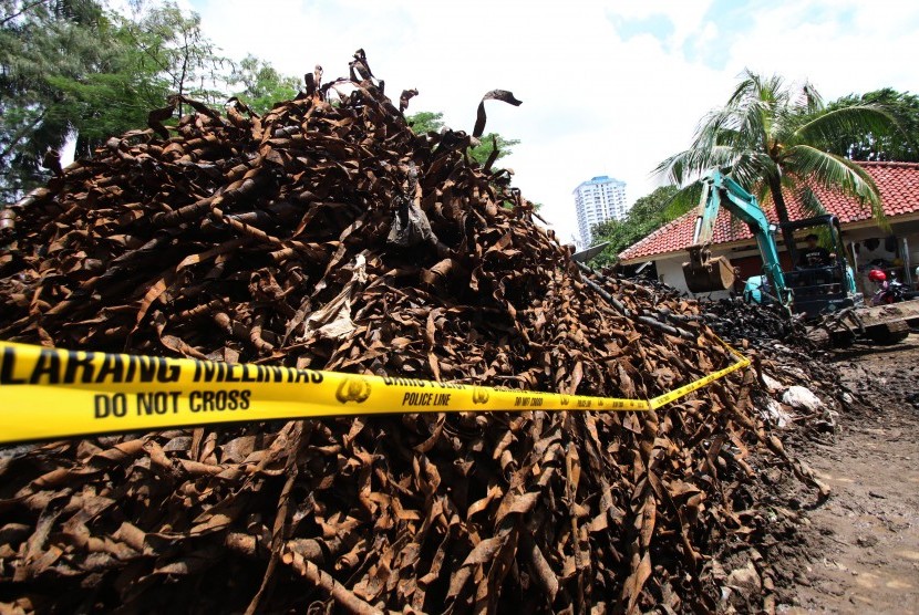 Petugas mengoperasikan alat berat guna merapikan tumpukan sampah kulit kabel listrik di tempat penampungan gudang kendaraan berat Sudin Tata Air Jakarta Pusat, Bendungan Hilir, Jakarta, Kamis (3/3).