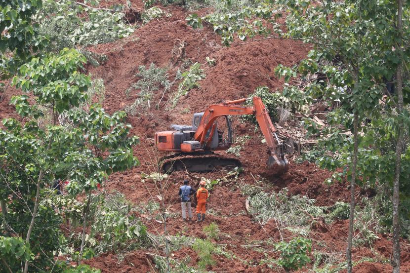 Petugas mengoperasikan alat berat untuk mencari korban tanah longsor di Desa Ngetos, Nganjuk, Jawa Timur, Senin (15/2/2021). Alat berat dikerahkan di kawasan longsor guna mencari 16 warga yang dinyatakan hilang.