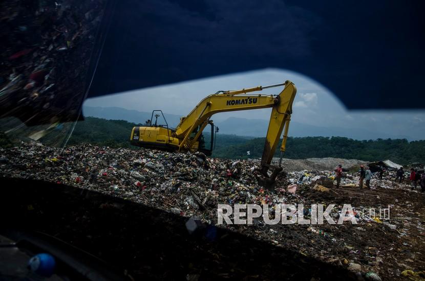 Petugas mengoperasikan alat berat untuk mengurai sampah di tempat pembuangan akhir sampah Sarimukti, Kabupaten Bandung Barat, Jawa Barat, Sabtu (19/2/2022). 