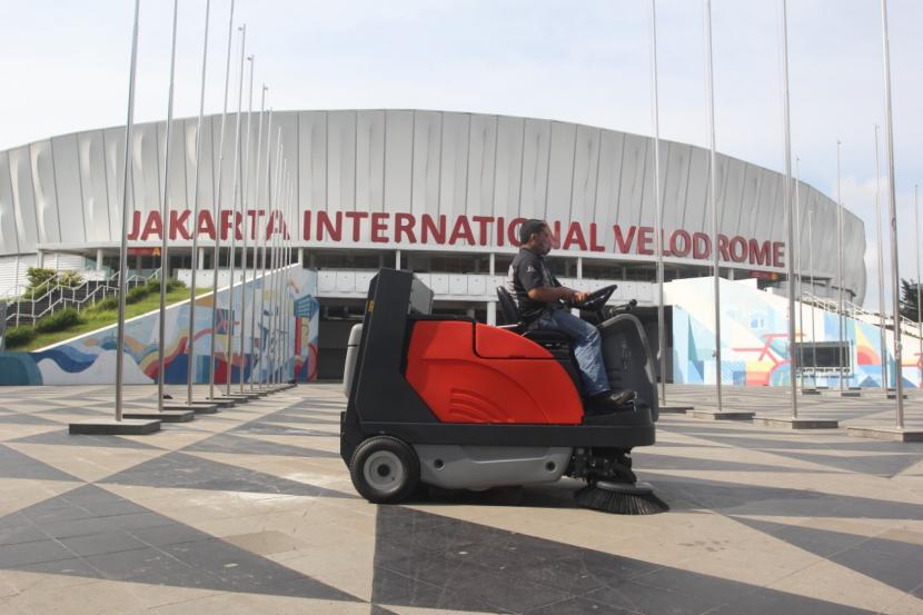 Petugas mengoperasikan mesin pembersih jalan dari PT Kobexindo Tractors Tbk (KOBX) di sekitar stadion Velodrome, Rawamangun, Jakarta Timur, Jumat (10/12).