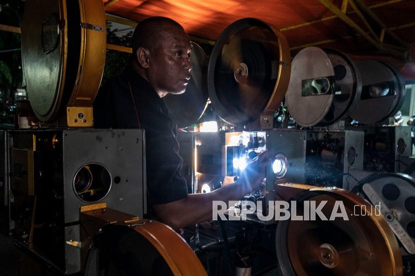 Petugas mengoperasikan proyektor film layar tancap saat pemutaran film Si Doel Anak Betawi karya Sjuman Djaya di halaman Perusahaan Umum Produksi Film Negara (Perum PFN), Jakarta, Kamis (31/3/2022). Perum PFN kini memiliki Immersive XR Studio (ImXR) pertama di Indonesia.