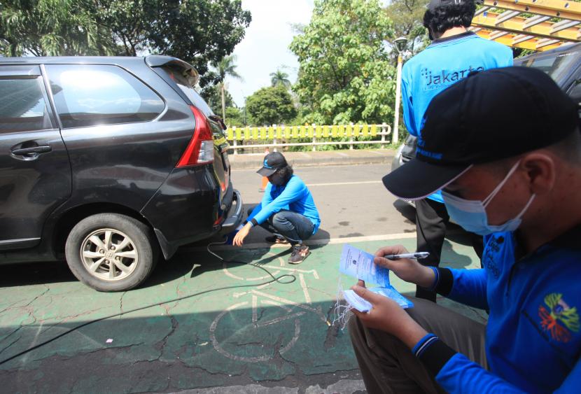 Petugas menguji emisi kendaraan gratis di Jalan Puri Lingkar Luar, Kembangan, Jakarta, Selasa (5/7/2022). 