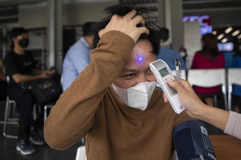 Petugas mengukur suhu tubuh calon penerima vaksin COVID-19 di Stasiun Manggarai, Jakarta Selatan, Rabu (13/7/2022). Data Satgas COVID-19 menyatakan hingga Rabu 13 Juli pukul 12.00 WIB penduduk Indonesia yang sudah menjalani vaksinasi dosis ketiga bertambah 166.302 sehingga total menjadi 52.214.963 orang. 