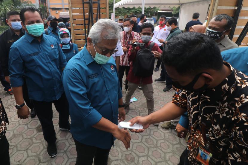Petugas mengukur suhu tubuh Ketua KPU Arief Budiman (tengah) saat menghadiri simulasi nasional pemungutan suara Pilkada serentak di Kediri, Jawa Timur, Sabtu (31/10/2020). Simulasi nasional yang dihadiri perwakilan KPU tingkat kota/kabupaten wilayah Indonesia timur tersebut sebagai upaya kesiapan KPU menyelenggarakan Pilkada serentak dengan menerapkan protokol kesehatan guna menanggulangi penyebaran COVID-19.