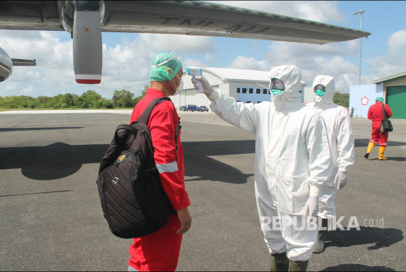 Petugas mengukur suhu tubuh pada badan awak pesawat Hercules C130 A-1333 dari Skadron Udara 32 di Landasan Udara Rsa Natuna Ahad (22/3l.