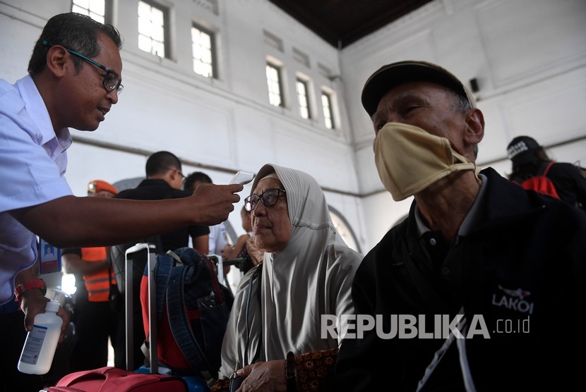 Petugas mengukur suhu tubuh penumpang kereta api saat sosialisasi pencegahan penyebaran virus Corona (COVID-19) di Stasiun Pasar Senen, Jakarta, Senin (9/3/2020).(Antara/Puspa Perwitasari)