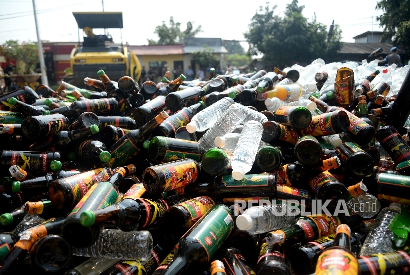 Petugas mengunakan alat berat memusnahkan barang bukti minuman keras (miras) di halaman Polsek Palmerah, Jakarta, Selasa (23/5).