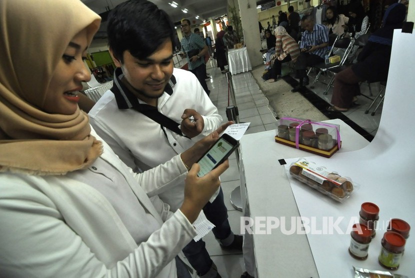 Petugas mengunggah foto salah satu produk UMKM yang telah didaftrakan untuk didaringkan, dengan berpartisipasi dalam program gerakan meng-online-kan 100.000 UMKM di Pasar Ciroyom, Kota Bandung, Jumat (31/3)