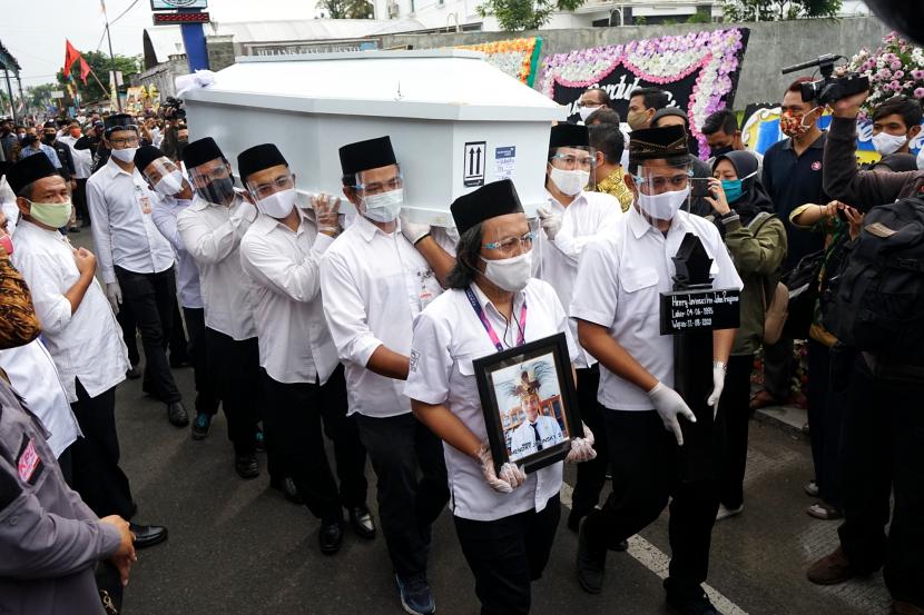 Petugas mengusung peti jenazah anggota KPU Yakuhimo, Papua almarhum Hendry Jovinski saat proses pemakaman di Rewulu Wetan, Sidokarto, Godean, Sleman, Yogyakarta.