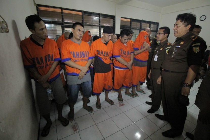 Petugas menilik sejumlah tersangka pembunuhan aktivis penolak tambang pasir Lumajang Salim 'Kancil' di Kejaksaan Negeri (Kejari) Surabaya, Jawa Timur, Kamis (21/1). 