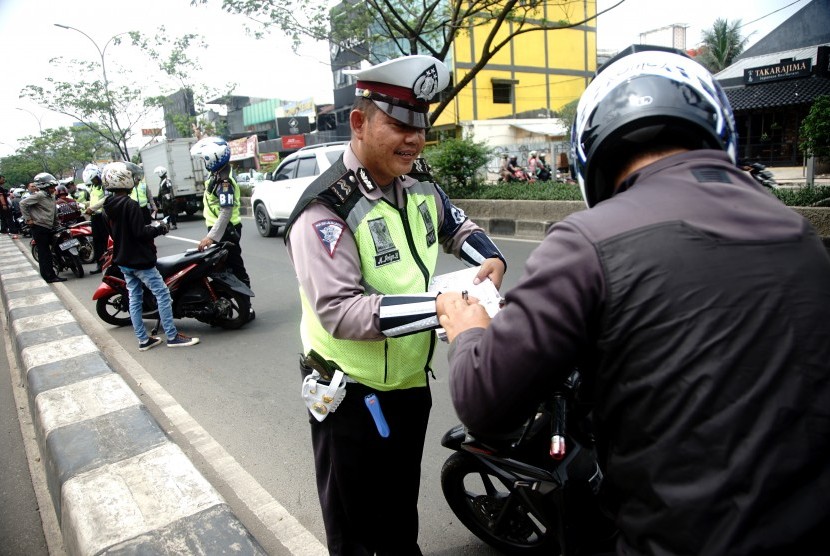 Petugas menindak pengendara motor yang memakai jalur mobil pada Operasi Zebra Jaya 2018 Di Margonda Raya Depok, Jawa Barat, Selasa (30/10/2018).