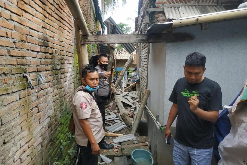 Petugas meninjau kondisi rumah rusak akibat gempa bumi di Kabuapaten Ciamis, Ahad (25/10). 