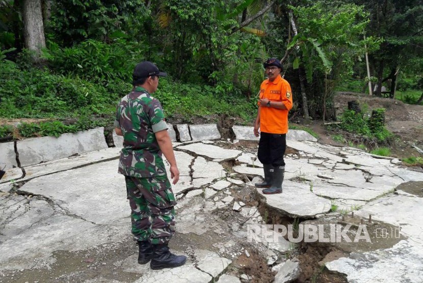 Petugas meninjau retakan akibat pergerakan tanah, di Desa Bantarkalong, Kecamatan Warungkiaraerjadi, Kabupaten Sukabumi, Senin (7/2). Dalam peristiwa tersebut, sejumlah rumah warga mengalami kerusakan.