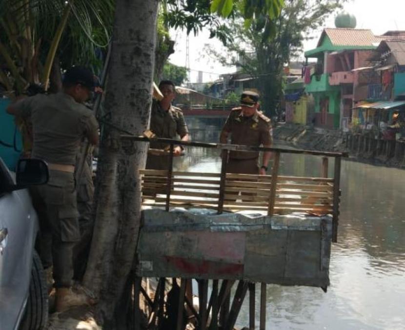 Petugas meninjau WC helikopter di Johar Baru, Jakarta Pusat, yang menjadi lokasi warga buang air besar langsung ke sungai.