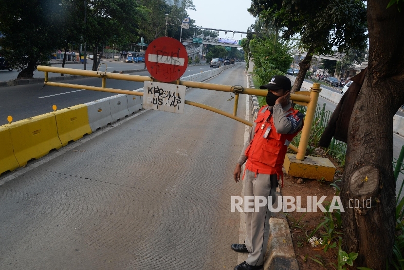 Petugas menjaga palang pintu jalur TransJakarta di Jalan Pramuka, Jakarta, Ahad (12/6).  (Republika/Yasin Habibi)