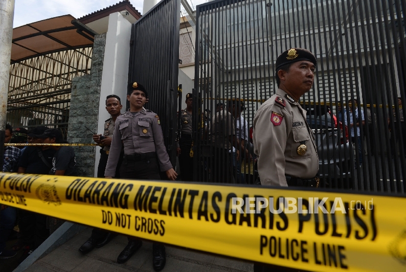 Petugas menjaga tempat kejadian perkara (TKP) kasus pembunuhan sadis di Perumahan Pulomas, Pulogadung, Jakarta Timur, Selasa (27/12). 