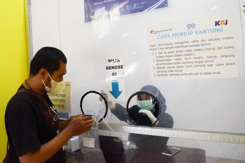 Petugas menjelaskan kepada calon penumpang Kereta Api (KA) cara melakukan tes deteksi COVID-19 dengan metode GeNose C19 di Stasiun KA Madiun, Jawa Timur, Sabtu (20/3). Penumpang kereta jarak jauh saat ini dapat memesan layanan Genose melalui aplikasi.