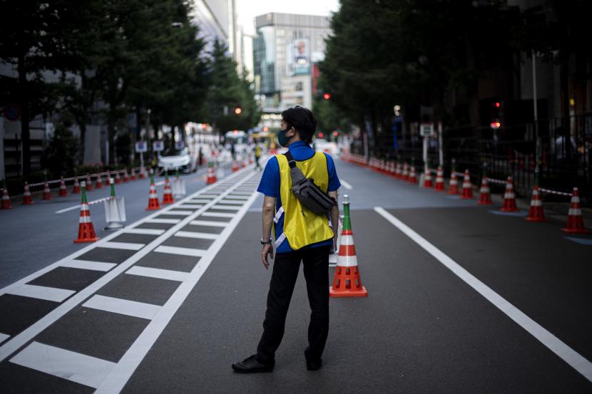 Petugas menunggu tibanya bus yang akan membawa peserta Olimpiade Tokyo 2020 di Tokyo International Forum, Tokyo, Jepang, Rabu (21/7/2021). Para peserta Olimpiade Tokyo 2020 harus menggunakan bus atau transportasi khusus selama kegiatan olahraga tersebut berlangsung untuk menghindari kemungkinan tertularnya COVID-19.