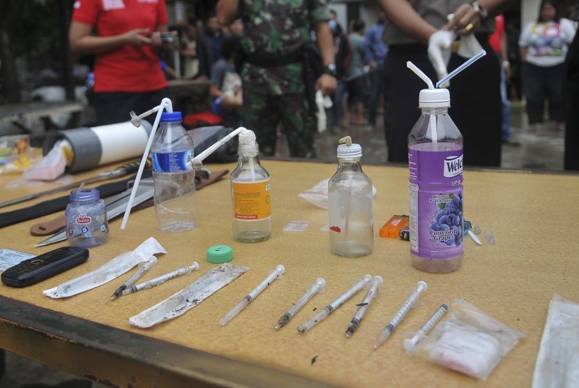 Petugas menunjukan barang bukti berupa alat suntik saat penggerebekan pengguna dan pengedar Narkoba di Jalan Bendi Besar, Jakarta, Rabu (2/3).