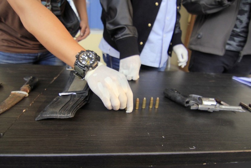 Petugas menunjukan barang bukti senjata api rakitan dan senjata tajam yang diamankan dari tersangka Saiful (25) setelah tim Gabungan Polda Metro Jaya dan Polda Lampung melakukan penangkapan di wilayah Lematang, Lampung Selatan, Minggu (9/7).